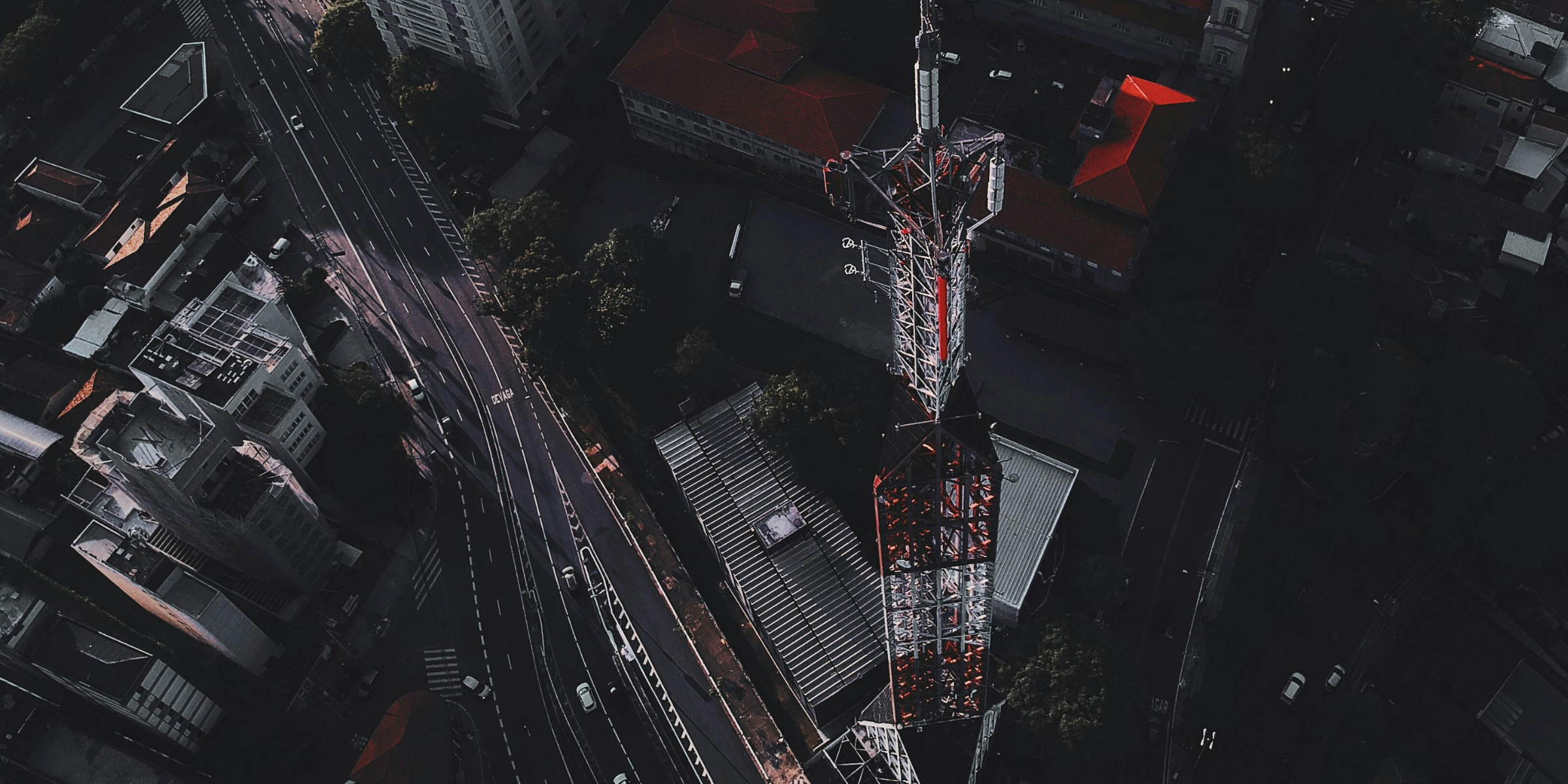 Overshot of a Cellular Tower with driving in the background in frame