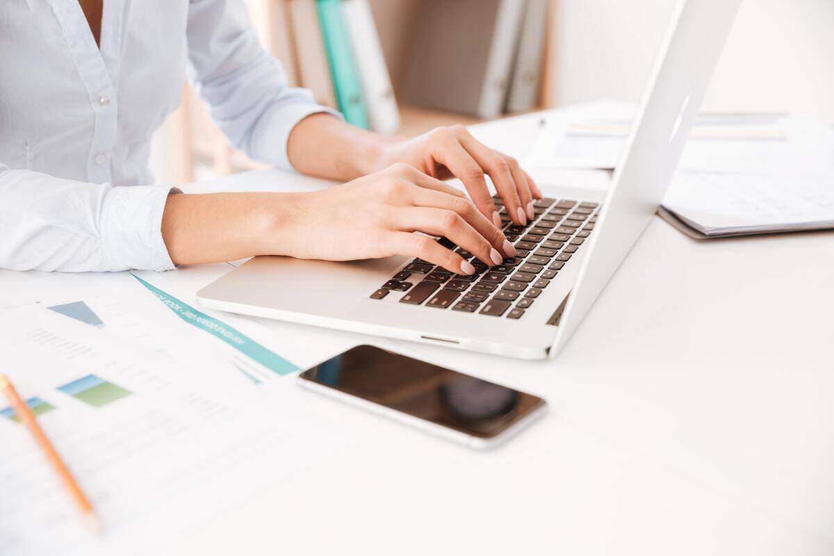 cropped-picture-of-businesswoman-dressed-in-white-shirt-sitting-in-her-office-and-usin-SBI-302898044-min